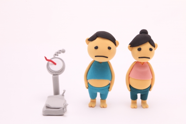 壊れた体重計と男女の人形